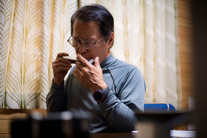 Man lighting a cigarette indoors with focused expression.